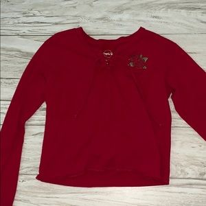a red long sleeve with a rose detail and a tie